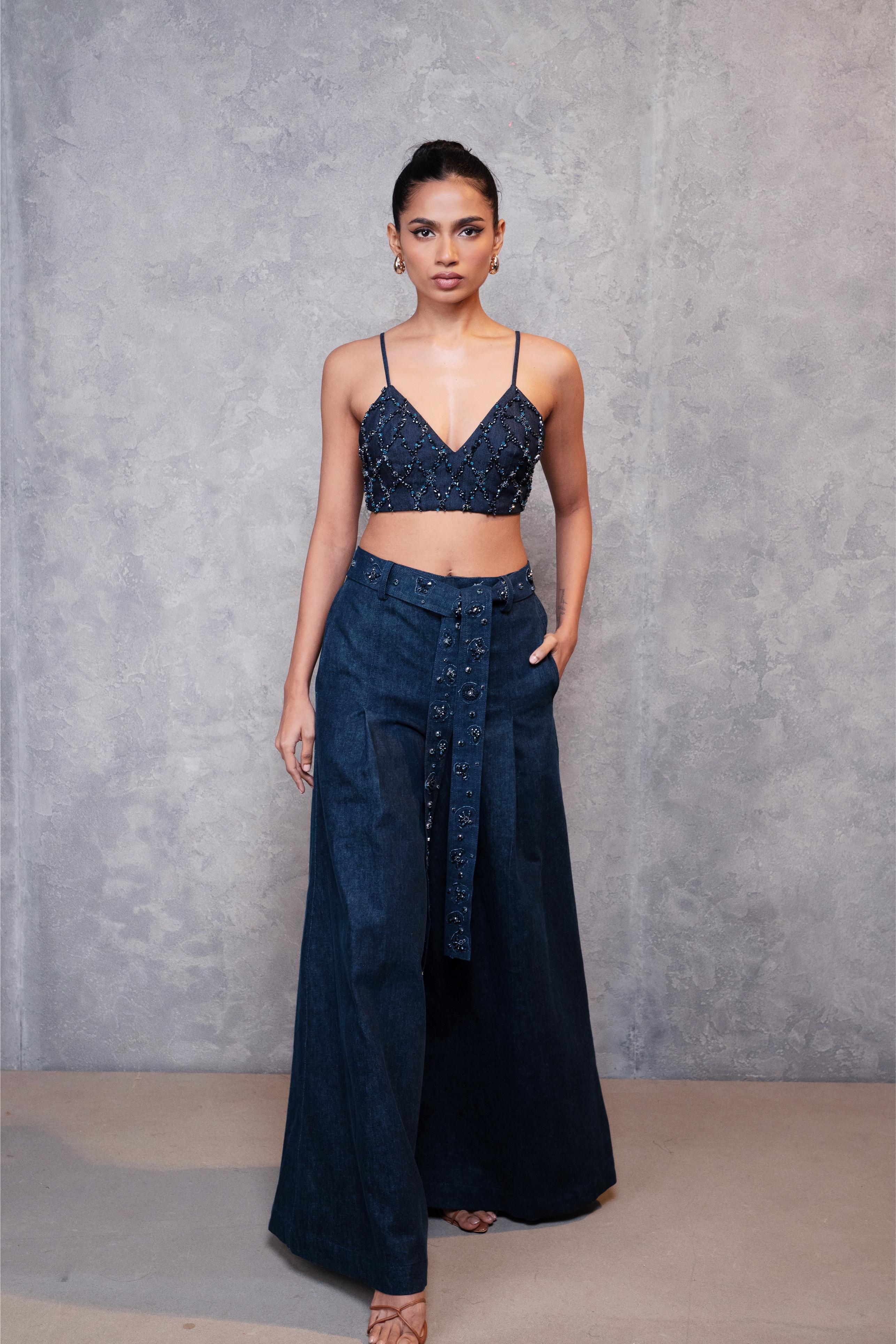 Woman wearing a dark blue sequin top and wide-leg pants