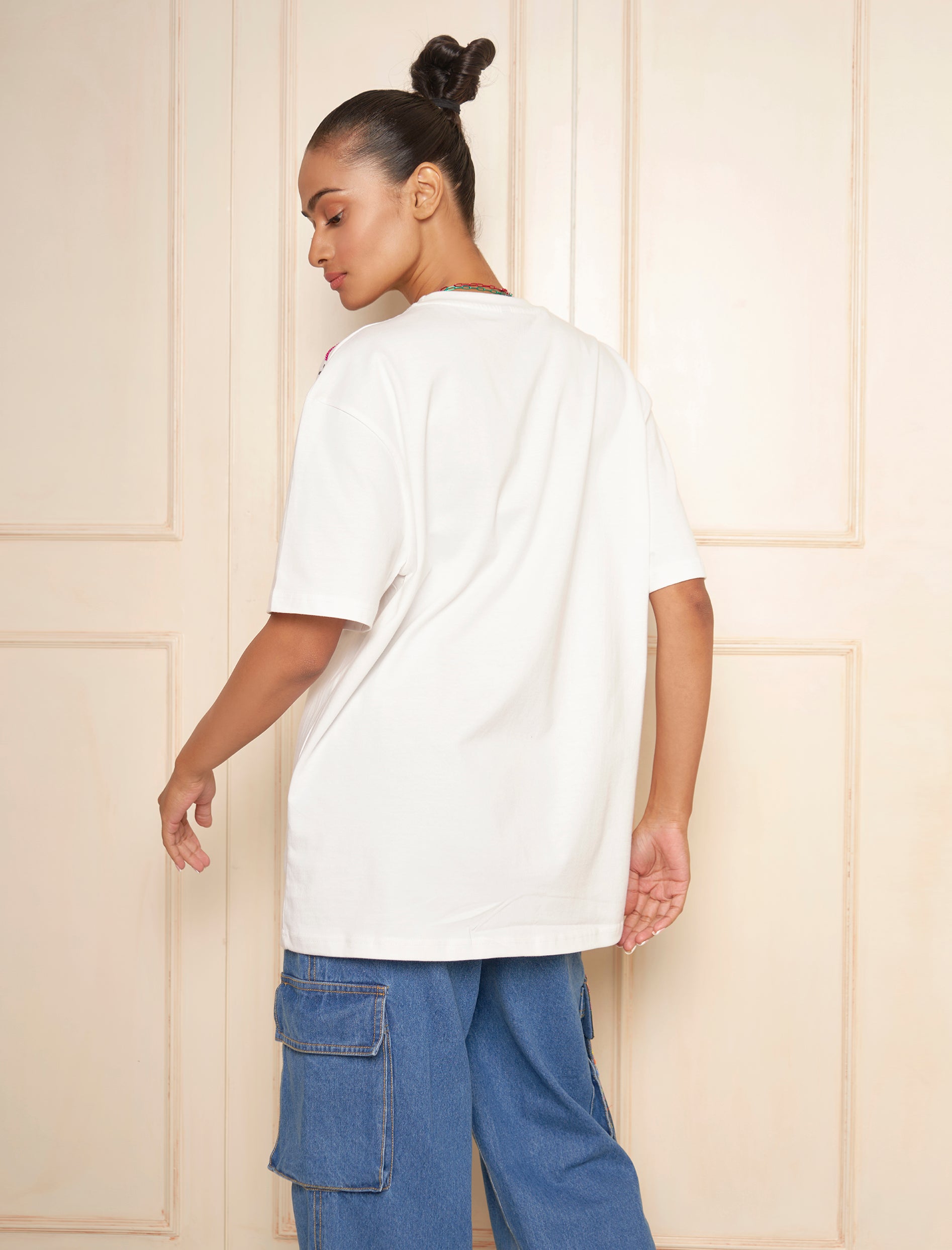 Wear a white oversized t-shirt with embroidered text on the left shoulder