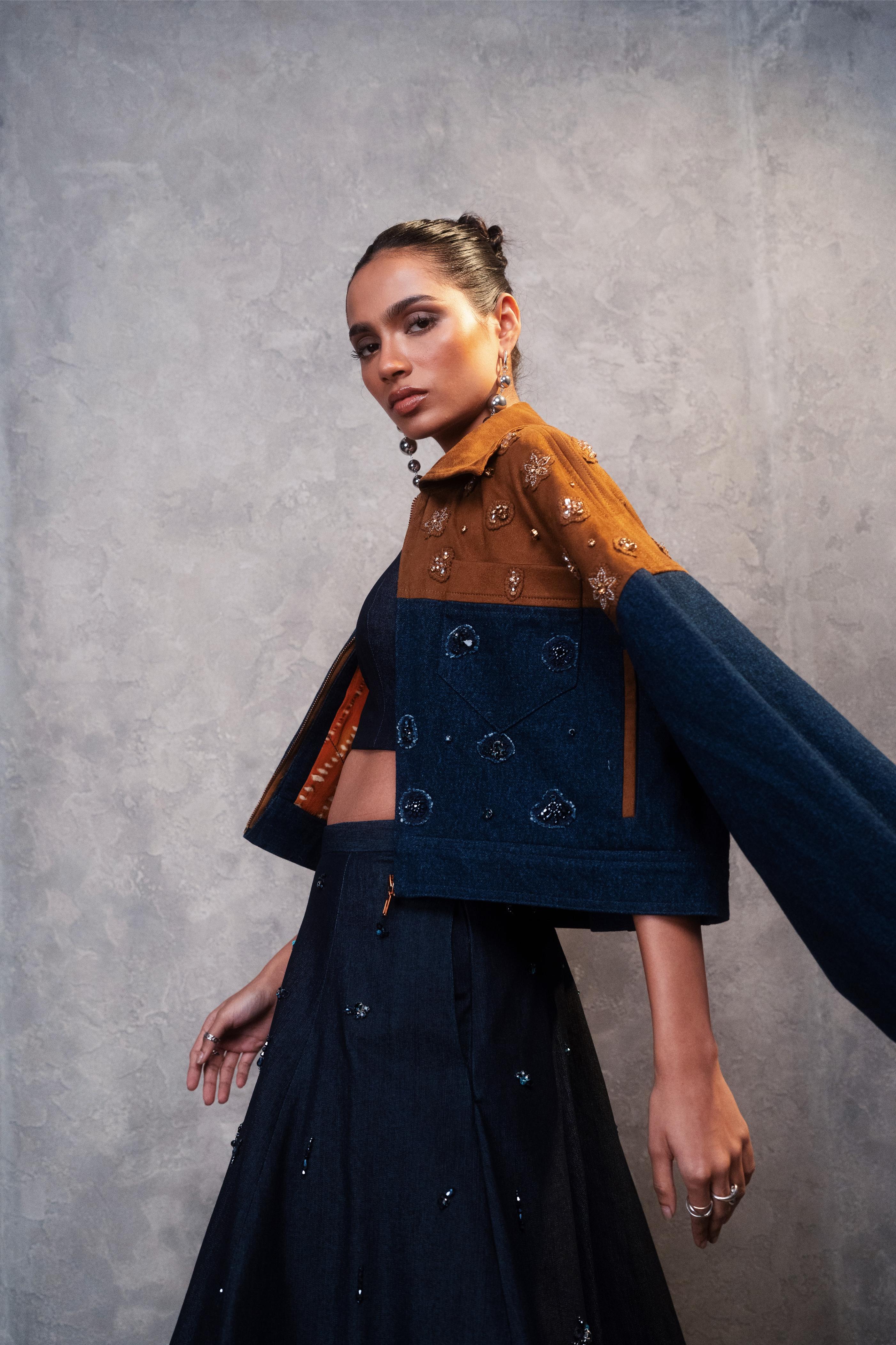 Woman wearing a dark blue outfit with a brown jacket