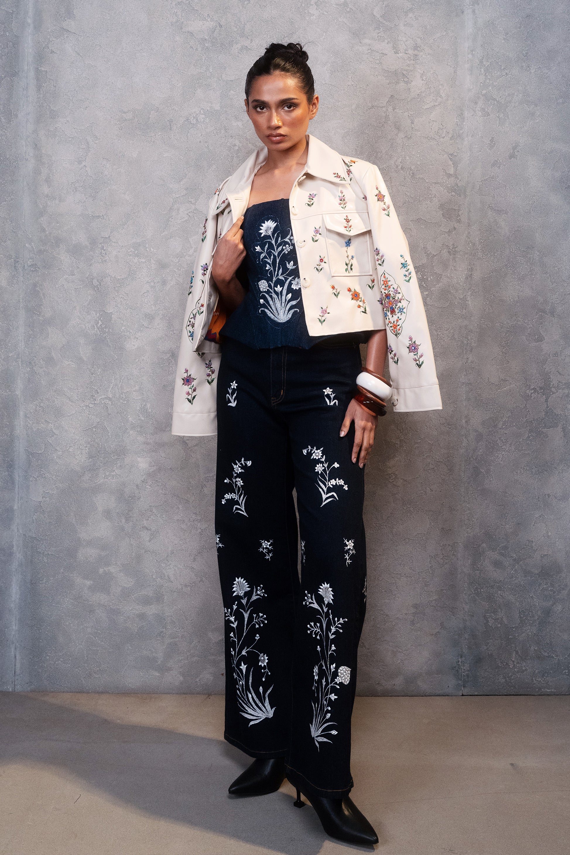 Woman wearing a floral embroidered jacket and pants